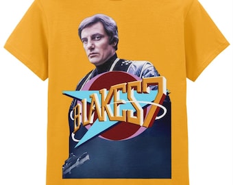 Op de afbeelding: Mosterdgeel T-shirt met een retro graphic. Het ontwerp toont een portret van een man en de tekst "BLAKES 7". De afbeelding bevat een rode cirkel, een blauwe pijl en een donkerblauwe achtergrond.