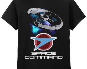 Op de afbeelding: Zwart T-shirt met een futuristisch ruimtestationontwerp boven een logo met een rode cirkel, blauwe pijl en de witte woorden "SPACE COMMAND". Het ruimtestation is zilver en wit, tegen een nevelachtergrond.