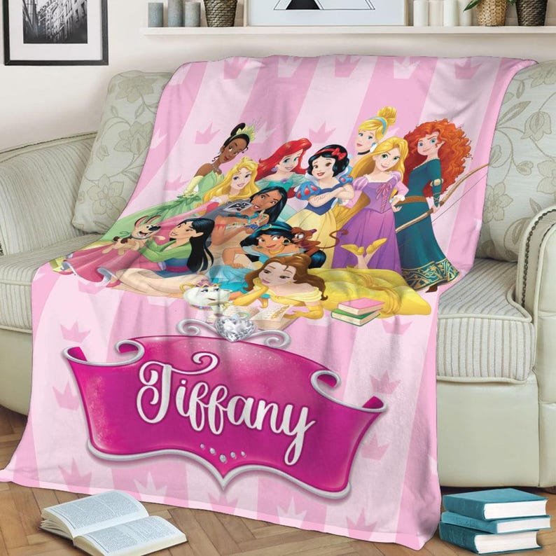 May include: Pink blanket featuring a group of cartoon princesses. The blanket has a vertical striped pattern with a banner that says "Tiffany". The princesses are in various dresses and poses.