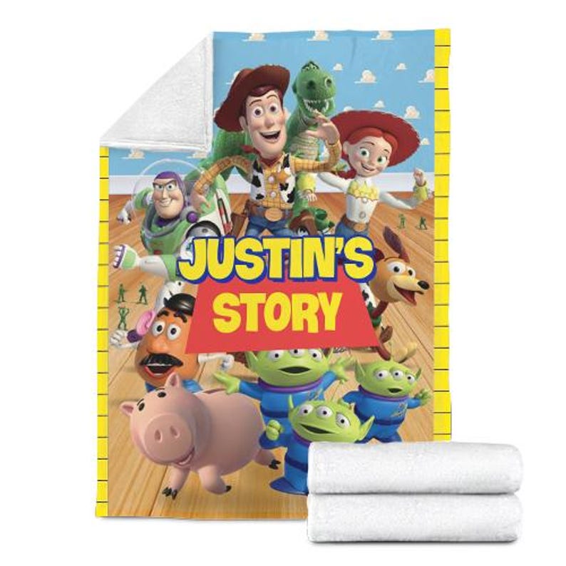 May include: A plush blanket featuring characters from the animated film Toy Story. The blanket has a colorful design with Woody, Buzz Lightyear, and other characters. The text "JUSTIN'S STORY" is prominently displayed.