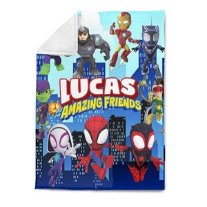 May include: A blue and white fleece blanket featuring various cartoon superheroes. The blanket has the text "LUCAS and his AMAZING FRIENDS" in red and yellow. The blanket is a soft, cozy item.
