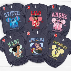 May include: Six navy blue t-shirts featuring characters from the animated film "Lilo & Stitch." Each shirt displays a different character's name in a collegiate font, along with the year "2002" and the phrase "Lilo and Stitch."