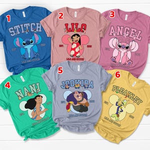 May include: A collection of six short-sleeved t-shirts featuring characters from the animated film "Lilo & Stitch." Each shirt displays a different character's name in a collegiate font, along with an image of the character and the text "Lilo and Stitch."