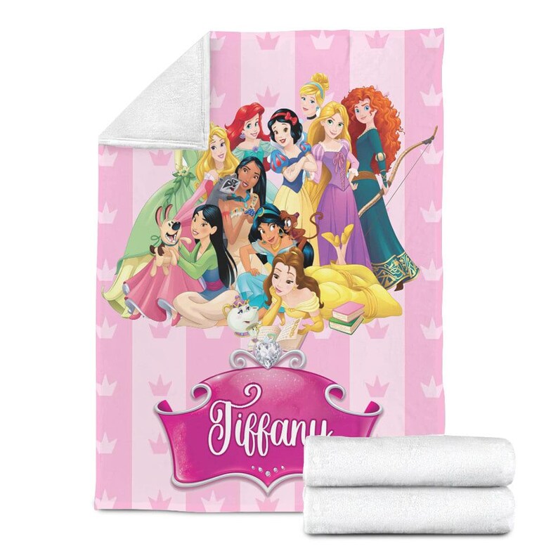 May include: Pink blanket featuring a group of cartoon princesses, with a pink and white striped background and crown accents. The name "Tiffany" is displayed in a pink banner. Two folded white towels are at the bottom.