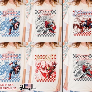 May include: A collection of off-white t-shirts featuring Marvel comic book characters including Captain America, Thor, Spider-Man, and Iron Man. Each shirt displays a graphic print with the character name, year, and a checkered border design.