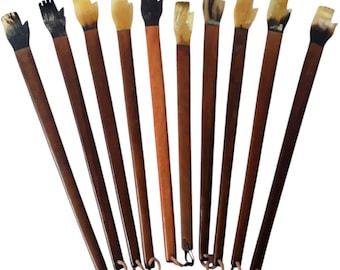 May include: A collection of ten wooden tools with hand-shaped tops. The handles are dark brown, with the hand-shaped tops in various colors, including black, tan, and cream. Each tool has a small copper ring at the base of the handle.