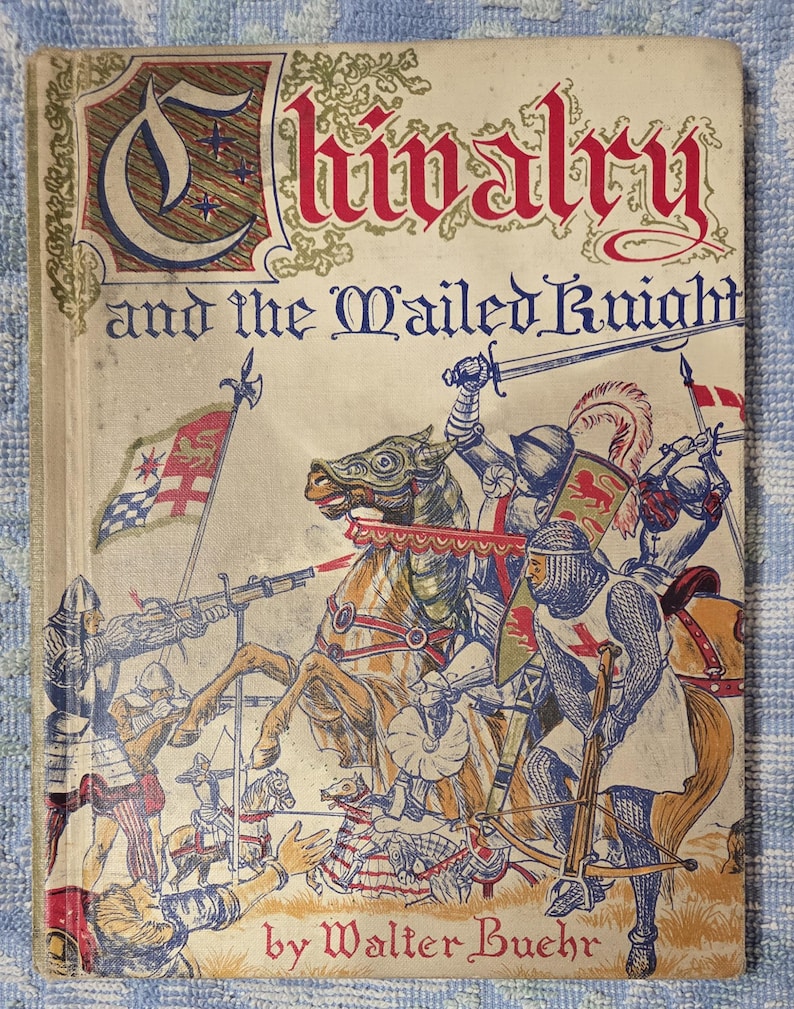 Puede incluir: Una portada de libro antiguo titulada "Chivalry and the Mailed Knight" de Walter Buehr. La ilustraci&oacute;n muestra caballeros con armaduras a caballo, luchando con espadas y ballestas. El t&iacute;tulo est&aacute; en rojo y azul, con adornos.