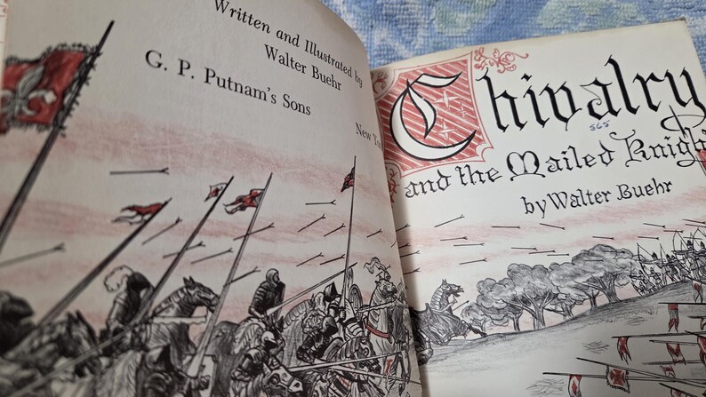 Puede incluir: Libro abierto titulado "Chivalry and the Mailed Knight" de Walter Buehr. La portada presenta una ilustraci&oacute;n de caballeros a caballo con banderas. Las p&aacute;ginas del libro son de color blanquecino con ilustraciones y texto en negro y rojo.