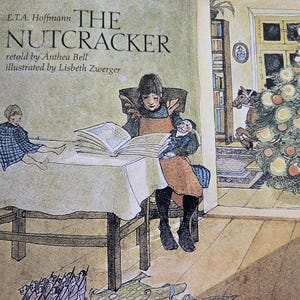 May include: A vintage children's book cover featuring an illustration of a girl reading a book with a doll sitting beside her. The book title is "The Nutcracker" by E.T.A. Hoffmann, retold by Anthea Bell and illustrated by Lisbeth Zwerger.