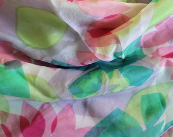 May include: A sheer fabric scarf with a colorful abstract floral pattern in shades of pink, green, and yellow.