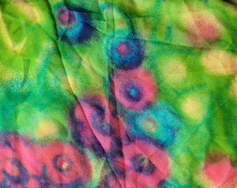 May include: Abstract floral pattern fabric with a green background and pink, blue, and yellow flowers.