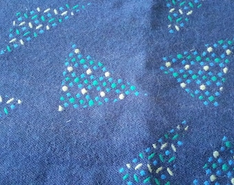 May include: Blue fabric with a repeating pattern of white, green, and blue triangles. The triangles are made of small dots and lines.