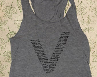 May include: A gray tank top with a list of vegetables written on it in black ink. The list includes beans, dill, broccoli, asparagus, spinach, scallions, popcorn, mushrooms, shallots, teas, chard, tomatoes, chili peppers, artichoke, rutabaga, chickpeas, turnips, sweet potatoes, cauliflower, palm hearts, summer squash, kidney beans, and radicchio.