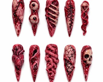 May include: A collection of ten grotesque, long, pointed fingernails. Each nail is a different design, featuring realistic, gory depictions of exposed flesh, organs, and sutures in shades of red and pink, creating a horror-themed aesthetic.