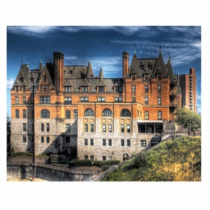 May include: A large, brick building with a castle-like design. The building has multiple towers and a large, arched entrance. The building is surrounded by green grass and trees.