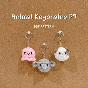 Puede incluir: Tres llaveros de animales hechos a mano con ganchillo: un pulpo rosa, un elefante gris y un perro blanco con manchas marrones. Cada llavero tiene un anillo plateado. Se muestra el texto "Animal Keychains P7" y "PDF PATTERN".