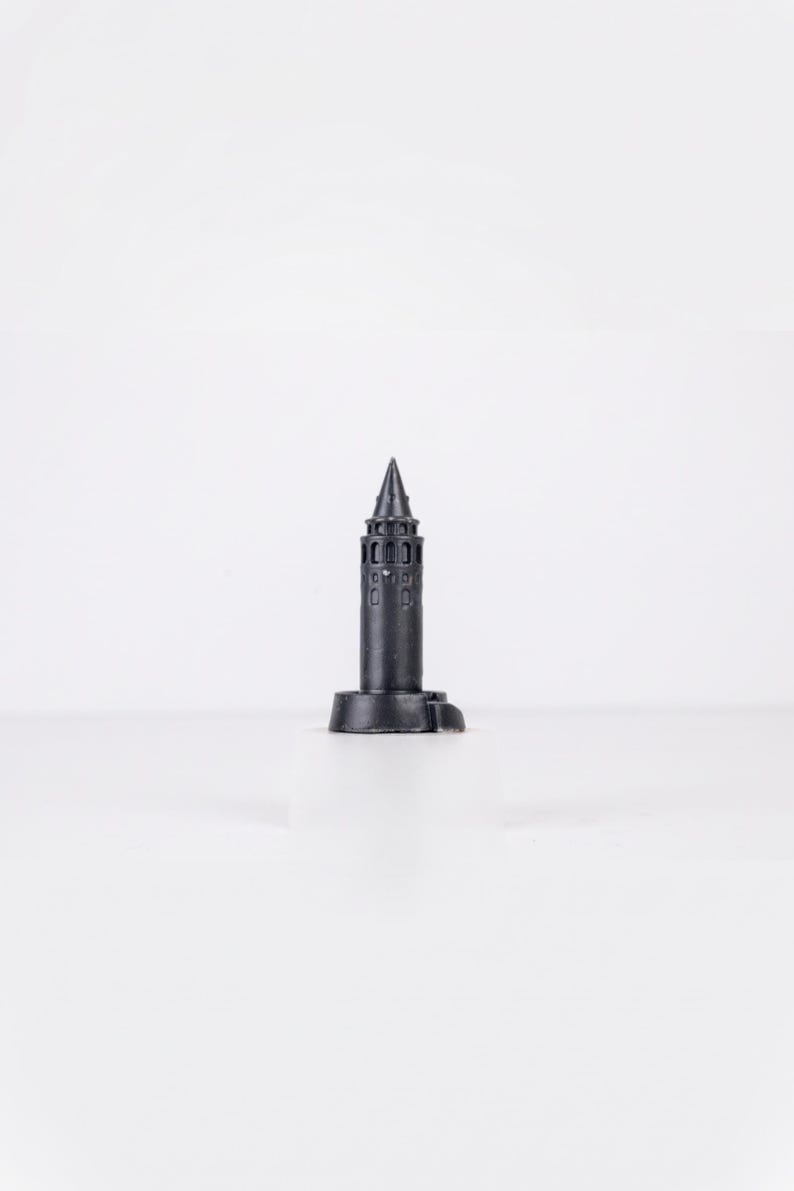 Black finish Galata Tower miniature with arched windows and a conical roof on a white background