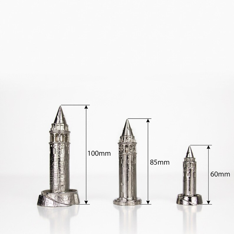 Three Galata Tower miniatures with height markings of 100 mm, 85 mm and 60 mm on a white background