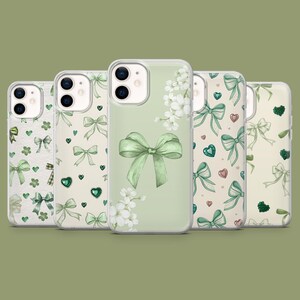 May include: Set of five clear phone cases with different green and white floral designs. Each case features a green bow with a white floral pattern and green hearts.
