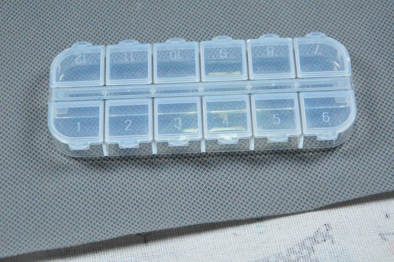 Peut inclure: Un pilulier en plastique transparent avec douze compartiments num&eacute;rot&eacute;s. Le bo&icirc;tier rectangulaire comporte un couvercle &agrave; charni&egrave;re pour chaque compartiment, con&ccedil;u pour la gestion quotidienne ou hebdomadaire des m&eacute;dicaments. Les compartiments sont num&eacute;rot&eacute;s de 1 &agrave; 12.