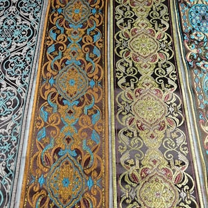 Peut inclure: Quatre bandes verticales de galon décoratif présentant des motifs tissés complexes. Les designs incluent des motifs floraux et géométriques répétitifs en fils dorés métallisés, turquoise vif, brun profond et noir avec une finition texturée.