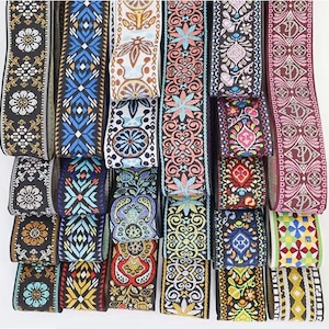May include: A selection of patterned ribbons in a variety of colours and designs. The ribbons display floral, geometric, and abstract patterns in shades of black, blue, red, orange, and green. These ribbons are suitable for crafts, sewing, or decorative purposes.