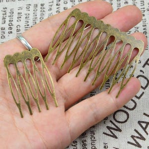 May include: Two antique bronze-colored hair combs. The combs have a decorative, openwork design with multiple tines. The metal has a slightly aged, vintage appearance. These hair accessories are suitable for various hairstyles.
