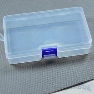 Op de afbeelding: Een doorzichtige plastic opbergdoos met een blauwe sluiting. De rechthoekige doos heeft een scharnierend deksel en is ontworpen voor kleine items. De doos staat op een grijze ondergrond.