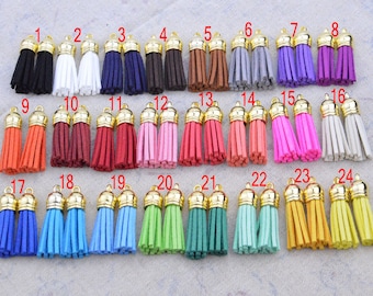 May include: Twenty-four pairs of small, colorful tassels with gold metal tops. The tassels are arranged in four rows of six pairs each.