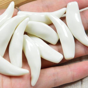 20 piezas de dientes de animales de plástico color marfil, cuerno de plástico, colgantes de dientes curvos y afilados sin agujero, colmillo