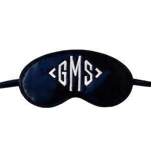 May include: A black satin sleep mask with white embroidered initials "GMS".
