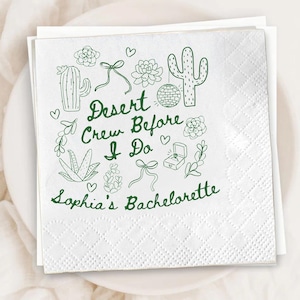 May include: White square paper napkins with a green desert-themed design. The napkins feature illustrations of cacti, succulents, bows, and a disco ball, with the text "Desert Crew Before I Do" and "Sophia's Bachelorette".
