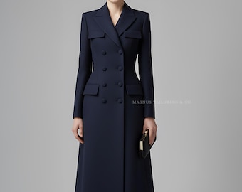 May include: A navy blue double-breasted coat with a tailored fit. The coat features a notched collar, flap pockets, and a knee-length hem. The text "MAGNUS TAILORING & CO" is visible. The model is wearing black heels and holding a black clutch.