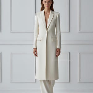 Side angle showing structured tailoring of ivory blazer coat