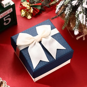Add-On: Elegante dunkelblaue Geschenkverpackung mit weißer Schleife, Geschenkbox für personalisierte Filmrollen-Schlüsselanhänger, perfekt für besondere Anlässe