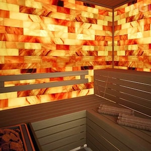 May include: A wooden sauna with a salt brick wall. The sauna has a wooden bench and a wooden door. The salt bricks are a warm orange color.