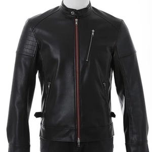 May include: Black leather jacket with a stand-up collar and a red zipper lining. The jacket has a zippered chest pocket and a small pocket on the left sleeve. The jacket is displayed on a white mannequin.