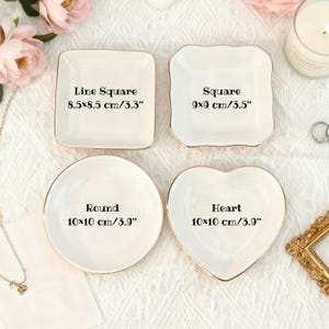 Puede incluir: Cuatro platos de cer&aacute;mica blanca para baratijas en forma cuadrada, redonda y de coraz&oacute;n, cada uno con borde dorado. Los platos cuadrados miden 8,5 cm, los redondos y en forma de coraz&oacute;n miden 10 cm. Texto en los platos.
