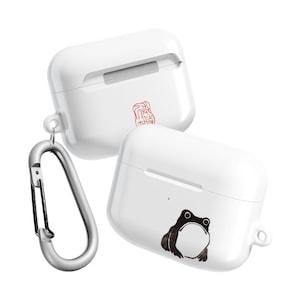 May include: White AirPods case with a black frog illustration and a silver carabiner clip. The case has a smooth, glossy finish and a small red stamp design. The frog illustration is on the front of the case.