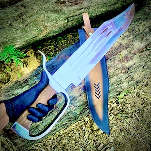 May include: A large, custom-made Bowie knife with a polished steel blade and a wooden handle. The blade has a unique, weathered appearance. It rests in a brown leather sheath with decorative arrow-like cutouts. The handle is held by a gloved hand.