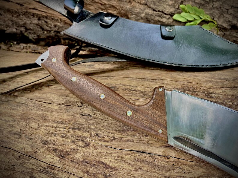 This heavy-duty machete is hand-forged from 1095 carbon steel and made to handle intense chopping, clearing, and survival tasks. Built with a full tang for added safety and strength. An ideal gift for outdoor lovers, this knife blends beauty and performance in one handcrafted piece.