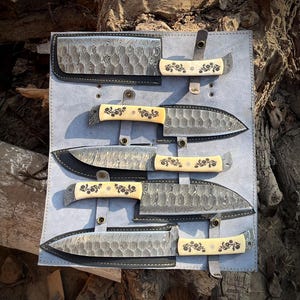 Complete view of the natural white handle 5 pcs chef knife set with leather roll kit laid out for display. Shows carbon steel blades, natural material handles and artisan workmanship. This handcrafted kitchen knife collection is designed for daily cooking, professional chefs and home kitchens.