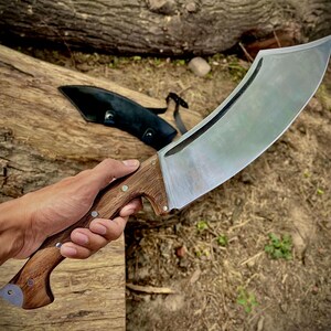 This full tang camping knife features a wide 1095 steel blade for heavy-duty outdoor use. Designed for bushcraft, hiking, and chopping, this machete-style knife is a great option for serious campers and survivalists. A personalized, handmade tool that also makes a unique gift for dads and outdoor lovers.