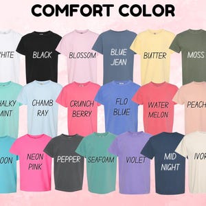 May include: A collection of Comfort Color t-shirts in various colors, including white, black, pink, blue, yellow, green, and more. Each shirt has a different color name printed on it. The text "COMFORT COLOR" is at the top.