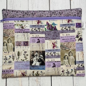 May include: A rectangular zippered pouch with a patchwork design. The fabric features vintage-style images, text, and floral patterns in shades of purple, cream, and lavender. The zipper is purple, and the top edge has a floral pattern.