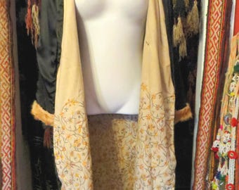 May include: A vintage black satin jacket with a tan floral patterned lining and fur trim. The jacket is open, revealing the intricate floral design. The garment is displayed on a mannequin, showcasing its elegant design.