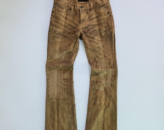 May include: Brown distressed denim jeans with a faded, textured appearance. The jeans feature multiple rips and patches, giving them a worn, vintage look. The jeans have a classic five-pocket design and a button and zipper closure.