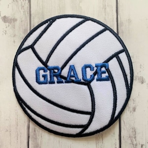 May include: White volleyball with black stitching and the word "GRACE" embroidered in blue.