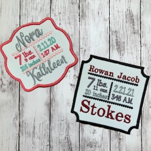 May include: Two personalised baby announcement patches with white backgrounds and black borders. The top patch is pink and says "Nora" with birth details: 7 lbs, 9 oz, 20.5 inches, 2.11.20, 1:37 AM, Kathleen. The bottom patch is blue and says "Rowan Jacob Stokes" with birth details: 7 lbs, 11 oz, 20 inches, 2.21.21, 3:46 AM.