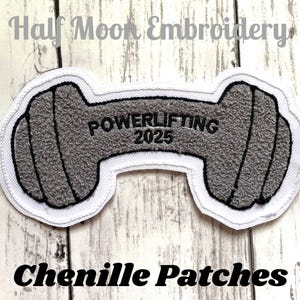 May include: Gray chenille iron patch with white stitching. The patch is shaped like a dumbbell and has the text "POWERLIFTING 2025" on it.